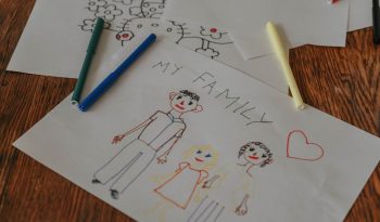 A hand-drawn family portrait using colored markers on paper, showcasing creativity and love.