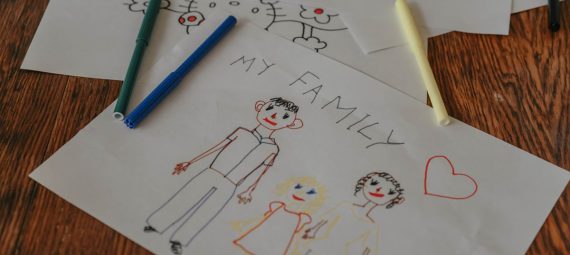 A hand-drawn family portrait using colored markers on paper, showcasing creativity and love.